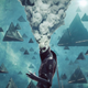 The Witness turns his back to look behind him as smoke billows from his head.